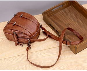 Detail view of the multi-layered zipper structure on a brown vintage PU leather small bag