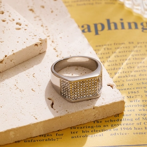 Macro shot of silver titanium ring with rectangular pavé-set zircons on stone background