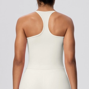 Detailed racerback design on cream high-elastic sports bra for gym and yoga training