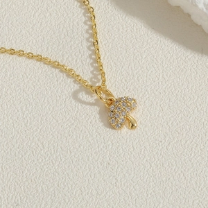 Macro shot of gold paperclip chain necklace with a crystal mushroom pendant detail