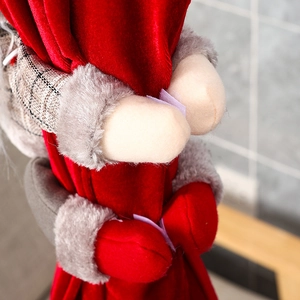 Detailed macro view of Christmas elf plush arm wrapped in red velvet fabric