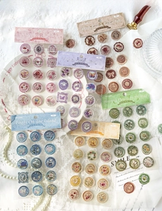 Close-up of vintage 3D wax seal stickers featuring floral, butterfly and angel patterns