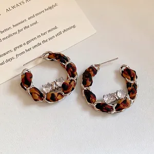 Boucles d'oreilles créoles en tissu léopard tressé avec détails en cristal