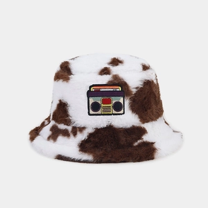 Detail of plush cow print bucket hat with vintage cassette radio patch for winter warmth