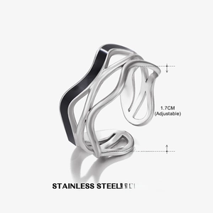Macro detail of silver wavy stainless steel ring with black enamel and adjustable size band