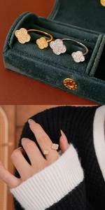 Detailed view of gold and silver four-leaf clover rings with sparkling zircon inlay