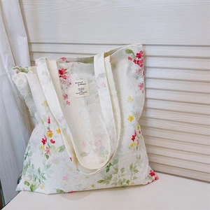 Close-up of ink-wash floral cotton tote with textured polka dots and fabric label
