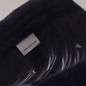 Vue macro de l'étiquette 100% coton et de la doublure intérieure de la casquette marine