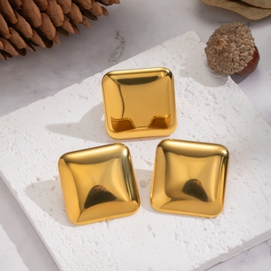 Polished 18K gold plated square stainless steel stud earrings on a textured stone base