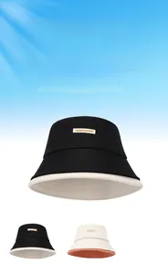 Dettaglio del tessuto anti-UV e dell'etichetta NEWFASHION su cappelli a secchiello