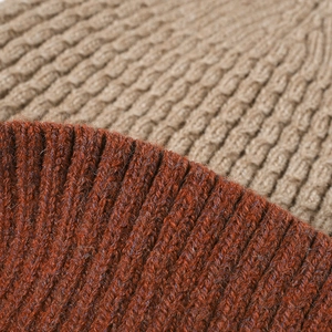 Winter knitted beanie featuring rust red and beige cable knit pattern with fleece lining