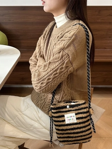 Petit sac en peluche à pois arc-en-ciel porté avec une tenue d'hiver élégante