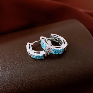 Détail macro de boucles d'oreilles vintage en argent avec perles turquoise et relief