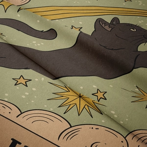 Detail of soft velvet fabric showing a black cat and golden stars on bohemian tapestry