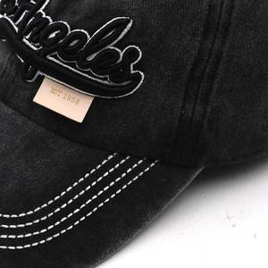 Macro detail of 3D Los Angeles embroidery and leather patch on vintage baseball cap
