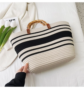Detailed view of woven tote bag featuring bamboo handles and stylish striped pattern