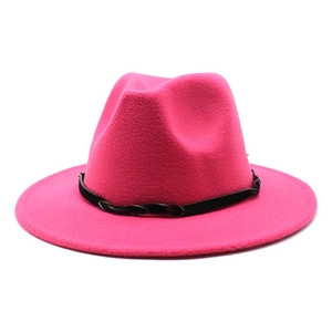 Detail of rose red fedora hat with wide brim and black woven decorative band texture