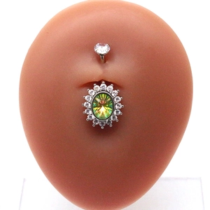 Close-up of silver belly button ring with iridescent oval gem and zircon crystals