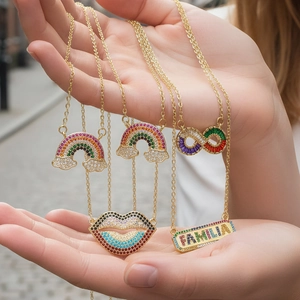 Detailed macro view of gold-plated necklaces with colorful zircon rainbow and lip charms