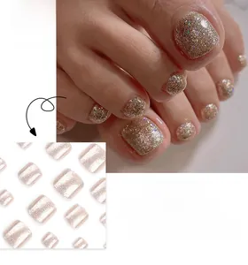 Gros plan d'ongles de pieds à paillettes dorées champagne avec une finition étincelante