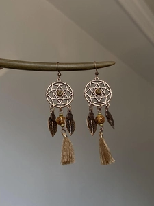 Boucles d'oreilles bohèmes avec feuille en bois évidée et pompon marron clair détaillé
