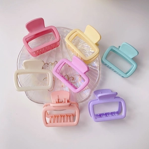 Colorful macaron square hair claws on a glass shell tray with clean background detail