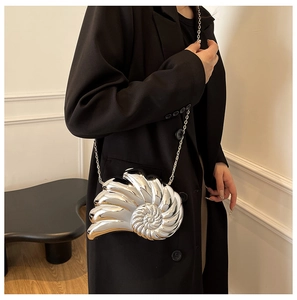 Silver nautilus clutch bag with acrylic chain worn with a professional black suit