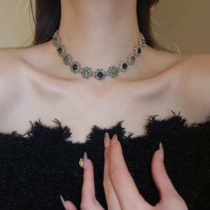 Close-up of vintage flower necklace with navy blue gemstones and sparkling rhinestones