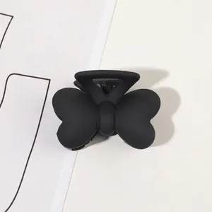 Macro shot of matte black butterfly hair claw clip with frosted texture finish