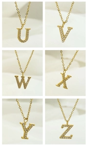 Detail view of gold-plated necklaces with U-Z letter pendants encrusted with zircons