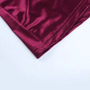 Gros plan d'une robe en satin bordeaux montrant la couture plate et le tissu brillant