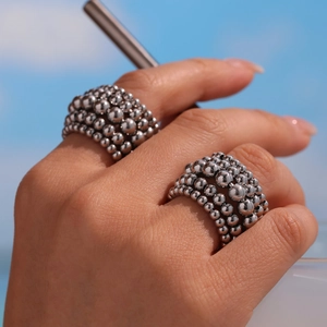 Layered silver ball chain open ring with metallic bead texture in outdoor light