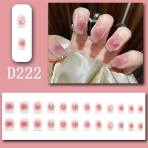 Detailed view of pink gradient press-on nails with 3D bows, glitter hearts, and micro beads