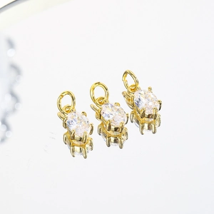 Close-up of gold-plated copper charms with oval clear zircon stones for DIY jewelry