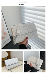 Detail of white geometric quilted crossbody bag with silver chain strap and modern texture
