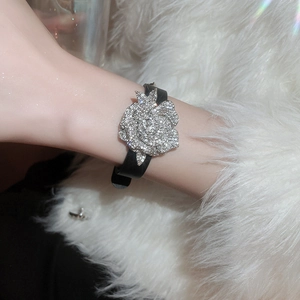 Detailschnalle mit Kristallblume an schwarzem Lederarmband an einem Handgelenk gezeigt