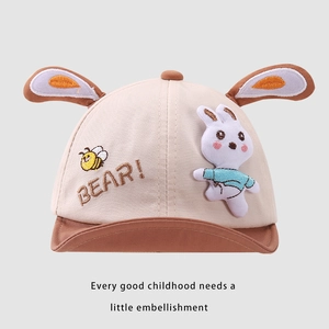Detail der Baby-Baseballkappe mit Plüsch-Hasenohren, Bienen-Stickerei und Hasen-Aufnäher