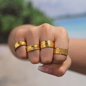 Set of four gold stainless steel rings featuring star smile and skull patterns on hand