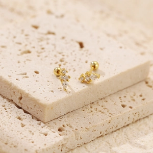Macro view of gold teardrop zircon stud earrings with secure screw ball backing