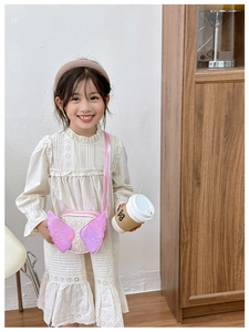 Pink sequin angel wing crossbody bag shown on a young girl for daily styling