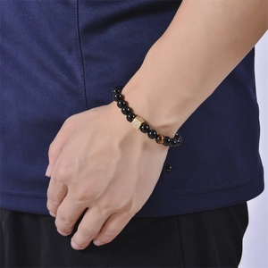 Close-up of black onyx and tiger eye stone bead bracelet with zircon letter A cube charm