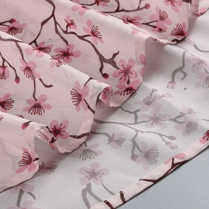 Détail macro du tissu mousseline rose avec motif cerisier et coutures impeccables