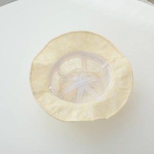 Detail view of baby sun hat with internal support strap and floral lace texture