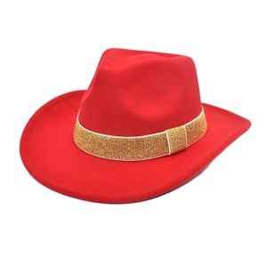 Gros plan d'un chapeau de cowboy en laine rouge avec ruban doré scintillant