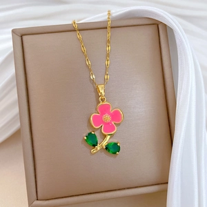 Détail du pendentif fleur rose avec feuilles vertes sur collier en or Figaro