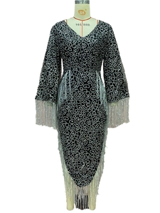 Close-up of V-neck dress featuring glitter polka dots and long fringe detailing on sleeves