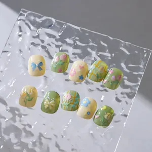 Detailed view of handmade short round nails with 3D tulip floral patterns and plaid design
