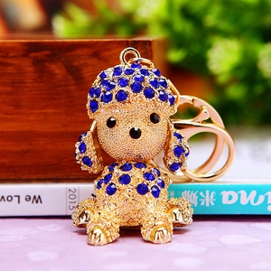 Detail of a gold dog keychain with dark blue rhinestones and elegant metallic finish
