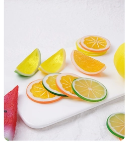 Detailed macro view of realistic PVC lemon, lime, and orange slices on a minimalist white tray