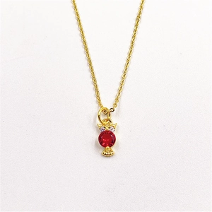 Detailed view of owl pendant necklace with gold plating and vibrant red center zircon